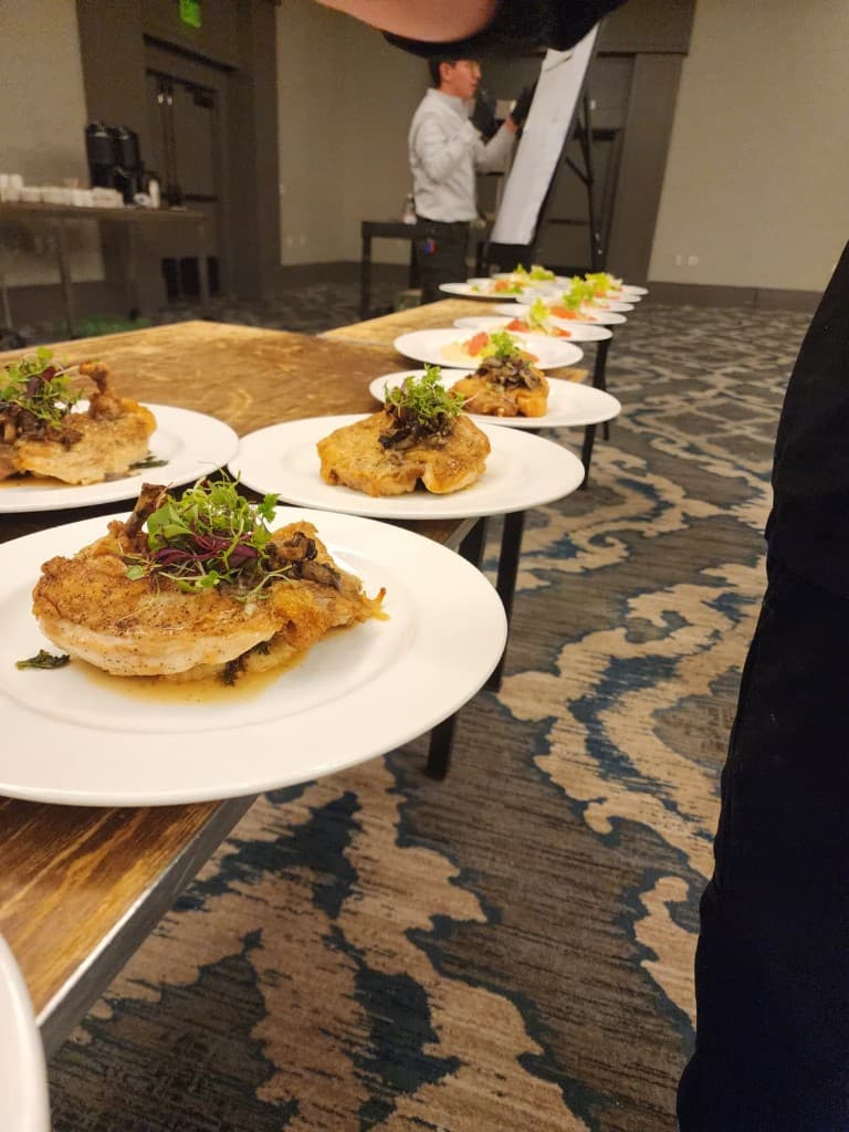 A row of plated Bornfidis courses lined up for service at a private event